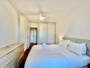 a bedroom with a large bed with a teddy bear on it at Charmant 2 pièces centre-ville in Cagnes-sur-Mer