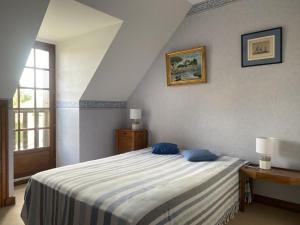 Un dormitorio con una cama con almohadas azules. en 753 - Belle maison à Erquy à 1km5 des plages et 2km5 du centre, en Erquy