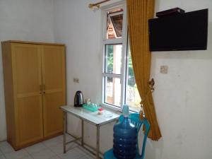 Zimmer mit einem kleinen Tisch und einem Fenster in der Unterkunft Hotel Raya in Plaosan