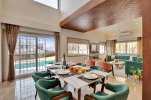 烏代浦的住宿－Elivaas Shourya Bliss 3BHK Villa with Pvt Pool, Udaipur，一间带桌椅的用餐室