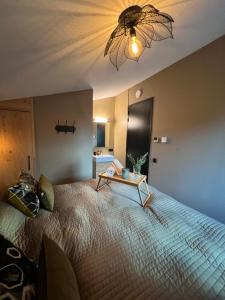 Un dormitorio con una cama grande y una mesa. en Parc La Dune South Africa Lodge en Warmenhuizen