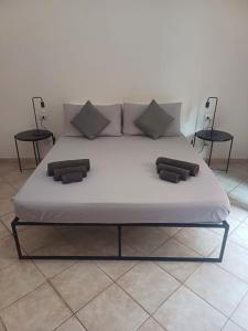 uma grande cama branca com duas almofadas em Repubblica 14 em Iglesias