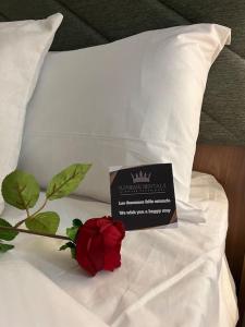 a red rose and a sign on a bed at 4 La Laguna, céntrico y acogedor in Las Lagunas