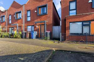 an empty street in front of a brick house at Stunning Manchester House - Garden in Manchester