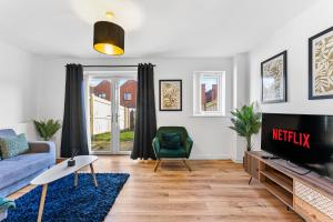 a living room with a couch and a tv at Stunning Manchester House - Garden in Manchester