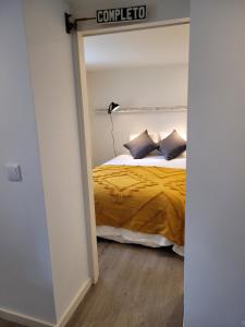 a bedroom with a bed with a yellow comforter at Apartamento Estoril in Estoril +5 photos
