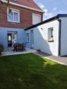 une maison avec une table de pique-nique dans la cour dans l'établissement Au fil de la lys, à Merville