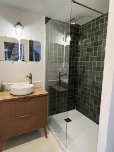 baño con lavabo y ducha con azulejos verdes en Maison de caractère, centre ville historique, en Malestroit
