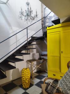 a staircase with a chandelier and a yellow cabinet at Casa Don Michele in Letojanni