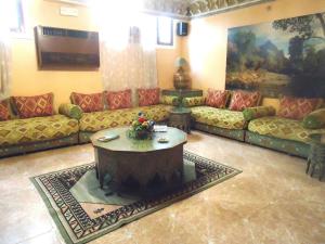 a living room with couches and a coffee table at Hotel Lixus in Nador