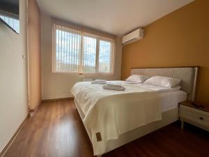 a bedroom with a bed with white sheets and a window at Nataly Homes 2 in Veliko Tŭrnovo