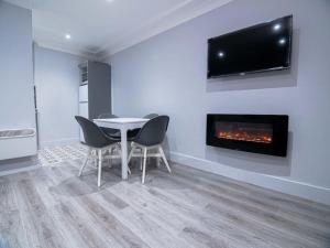 a dining room with a table and a fireplace at City Walk Apts in Dublin