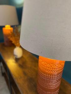 an orange and white lamp on a wooden table at Temper Mill 3 BR Garden & FREE parking in Newport
