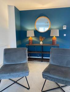 Duas cadeiras num quarto azul com um espelho em Temper Mill 3 BR Garden & FREE parking em Newport