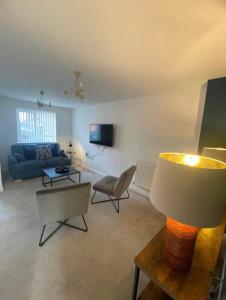 un soggiorno con divano e tavolo con lampada di Temper Mill 3 BR Garden & FREE parking a Newport