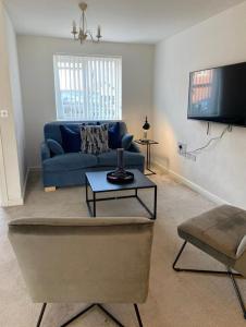 uma sala de estar com um sofá azul e uma televisão em Temper Mill 3 BR Garden & FREE parking em Newport