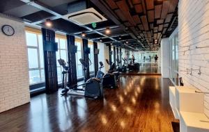 een fitnessruimte met loopbanden en crosstrainers in een gebouw bij Apt Roseville Soho and suite studio w/ wifi & pool in Dadap