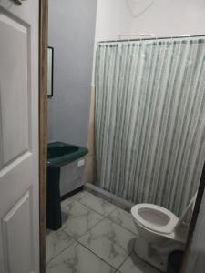 a bathroom with a shower curtain and a toilet at Mi Casa Tica Backpackers in Monteverde Costa Rica