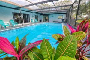 a swimming pool with plants in front of a house at 5 Bed/3 Bath Waterfront / Pool in Hernando Beach
