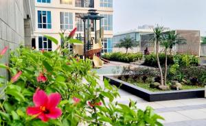 een tuin met bloemen en planten voor een gebouw bij Apt Roseville Soho and suite studio w/ wifi & pool in Dadap