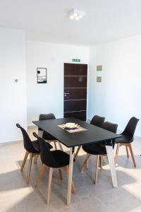 a dining room with a black table and chairs at PH Patagonia Carrera Aparts in Puerto Madryn
