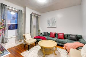 uma sala de estar com um sofá verde e almofadas vermelhas em Pet-Friendly Salem Apartment with Shared Deck! em Salem