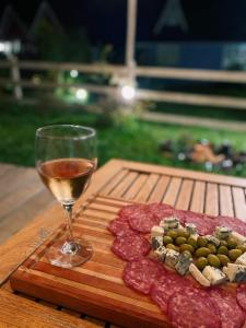kieliszek wina obok talerza mięsa i sera w obiekcie Casa de temporada - Recanto da invernada w mieście Urubici