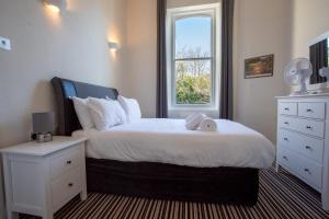 a bedroom with a large bed with a window at Cosy Flat in Victorian Villa- Parking & Garden in Torquay