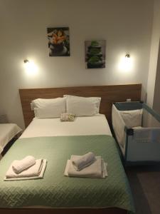 a bedroom with a bed with two towels on it at Charoula's Apartments in Syvota