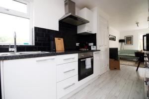 een keuken met witte kasten en een fornuis met oven bij 4 BR with FREE on street parking in Bristol