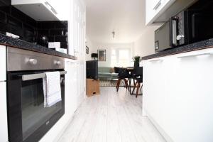 uma cozinha com electrodomésticos a preto e branco e uma sala de jantar em 4 BR with FREE on street parking em Bristol