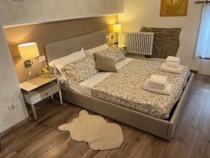 a bedroom with a large bed with a nightstand and a table at DOMUS TUSCIA APARTMENTS San Faustino guesthouse in Viterbo