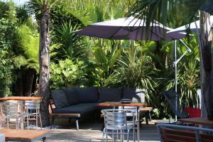 a patio with a couch and tables and an umbrella at Hotel Pavillon Imperial in Menton +111 photos