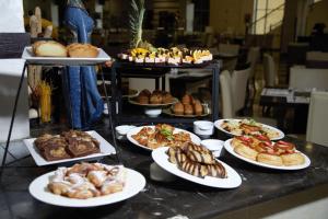 una mesa con platos de bollería y otros pasteles en East hotel en Sowayma