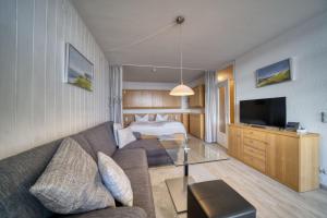 un soggiorno con divano e letto di Ferienpark - Haus H, App 0H0902 a Heiligenhafen