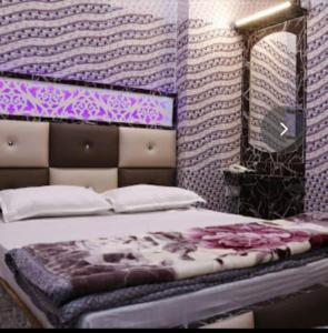 sypialnia z łóżkiem z lustrem i fioletowymi ścianami w obiekcie Hotel Pari w mieście Dźalandhar