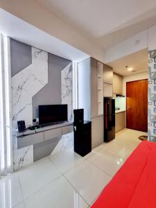 een woonkamer met een keuken met een koelkast bij Apt Roseville Soho and suite studio w/ wifi & pool in Dadap