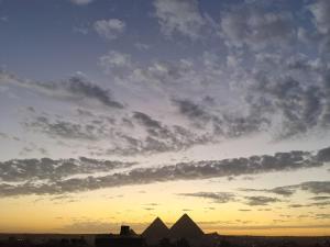 een uitzicht op de piramides onder een bewolkte hemel bij Bedouin Pyramids View in Caïro