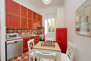 una cucina con armadi rossi, tavolo e frigorifero rosso di Super appartamento nel cuore del Pigneto a Roma