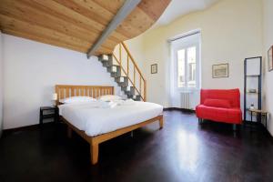 una camera con letto e sedia rossa di Super appartamento nel cuore del Pigneto a Roma