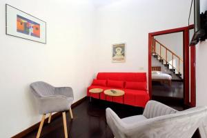 un soggiorno con un divano rosso e 2 sedie di Super appartamento nel cuore del Pigneto a Roma