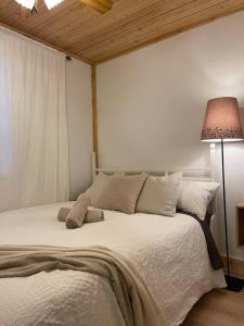 1 dormitorio con 1 cama blanca grande con lámpara en Waterfront private cottage on Koshlong Lake, en Haliburton