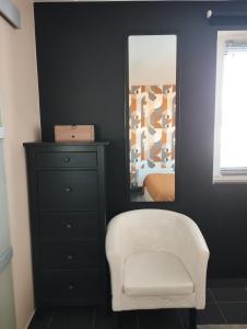 ein Schlafzimmer mit einem weißen Stuhl und einem Spiegel in der Unterkunft Sweetnest by home in Waterloo