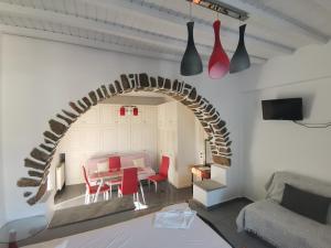 un soggiorno con tavolo e arco di VILLA VASILIS ORNOS a Mykonos Città