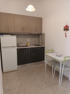 a kitchen with a white refrigerator and a table at Charoula's Apartments in Syvota