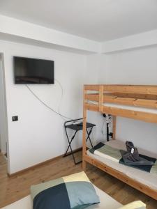sypialnia z 2 łóżkami piętrowymi i telewizorem z płaskim ekranem w obiekcie Vila Cri Cri w mieście Buşteni