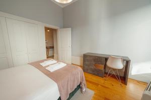 1 dormitorio con cama, escritorio y silla en Formosa Deluxe by Hosty en Oporto