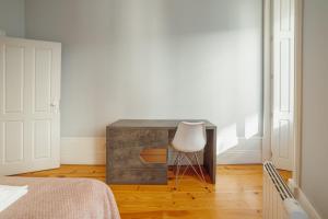 1 dormitorio con escritorio y silla junto a la cama en Formosa Deluxe by Hosty en Oporto