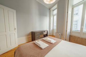 1 dormitorio con 1 cama con 2 toallas en Formosa Deluxe by Hosty en Oporto