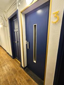 une porte bleue dans un couloir avec un numéro cinq dans l'établissement Comme une suite près du métro, à Clichy